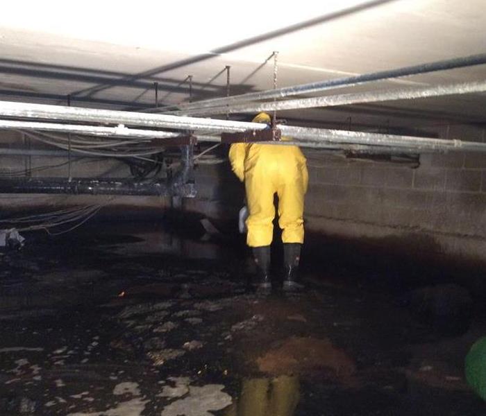 water flooded in crawlspace being extracted by worker