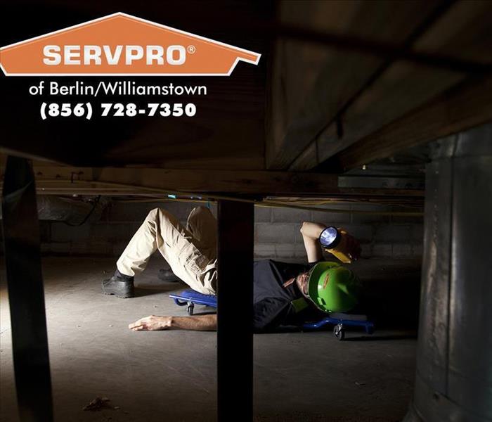 Employee in a crawl space underneath a Berlin, New Jersey home.