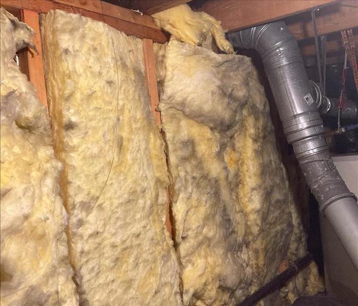 Smoke damaged insulation in an attic.